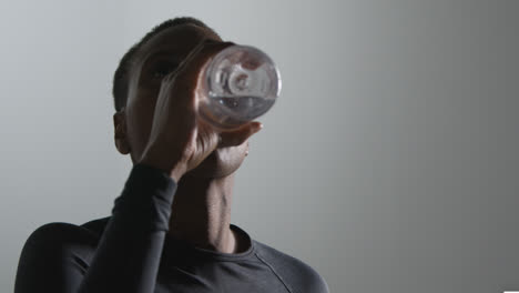 Close-Up-Studio-Shot-Of-Woman-Wearing-Gym-Fitness-Clothing-Drinking-Water-After-Exercise